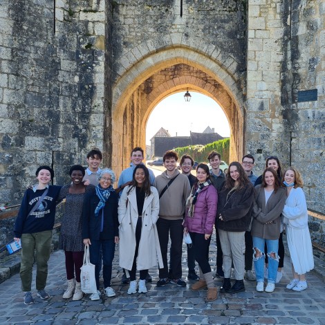 The group stands together by the city wall and tower.